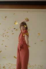 A young beautiful girl in a red overalls is dancing and throwing a bagura. Festive mood. Body positive