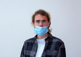 A side view of a Spanish young bearded male wearing a protective facemask incorrectly