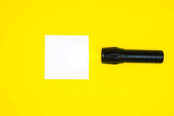 Blank white To Do List Sticker with black flashlight. Searching information on the Internet..Close up of reminder note paper on the yellow background. Copy space. Minimalism, original and creative.