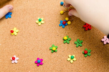 flower meadow. Pin a blossom. Children game on cork board with colored map pins. Exercise for fine motoric skils, hand coordination. 