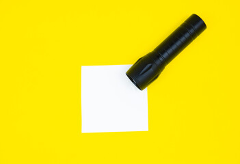 Blank white To Do List Sticker with black flashlight. Searching information on the Internet..Close up of reminder note paper on the yellow background. Copy space. Minimalism, original and creative.
