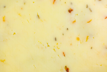 Yellow cheese with herbs and spices background Texture . Close up, macro photo.