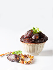 Dates fruit and rosary still life against on white background. Ramadan background greeting card. Ramadan Kareem.