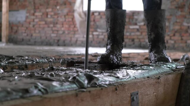 Worker man align the level of liquid monolithic foam concrete for warming and sound insulation of house.