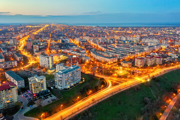 Fototapeta na wymiar Galati, ROMANIA - March 19, 2021: Aerial view of Galati City, Romania. Night city lights after sunset at blue hour
