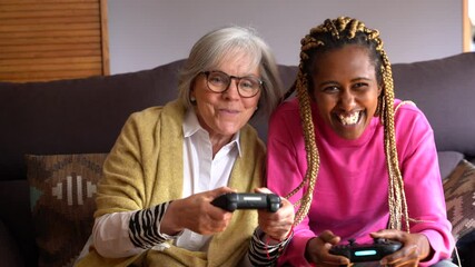 Young black woman next to an older woman playing a console game