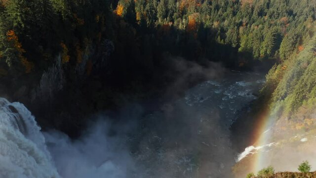Flying along the Snoqualmie waterfalls with rainbow in Washington, USA