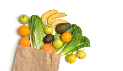 Top view paper bag with different groceries, isolation on white background. Food diet set fresh romaine lettuce leaves, apples, oranges, bananas, avocados and grapefruit.