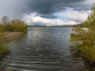 A view across a sailing lake at Thrapston, Northamptonshire as a storm develops