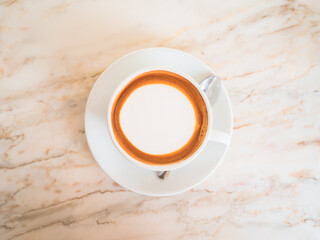 Top view of hot coffee Cappuccino, espresso in the white cup put on the marble table in cafe morning work day background.