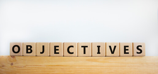 Objectives symbol. Word 'objectives' written on wooden blocks. Business and objectives concept. Copy space. Beautiful white background.
