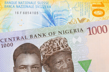 A macro image of a blue, purple and green one thousand  naira note from Nigeria paired up with a yellow Swiss ten franc bill.  Shot close up in macro.