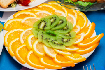 Fruit salad. Oranges and kiwi slices laid out on a plate. Sweet dessert. A healthy citrus meal.