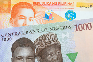 A macro image of a blue, purple and green one thousand  naira note from Nigeria paired up with a orange and white twenty piso note from the Phillipines.  Shot close up in macro.