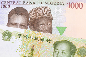 A macro image of a blue, purple and green one thousand  naira note from Nigeria paired up with a green and white one yuan note from China.  Shot close up in macro.