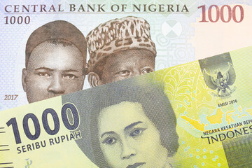 A macro image of a blue, purple and green one thousand  naira note from Nigeria paired up with a green one thousand bank note from Indonesia.  Shot close up in macro.