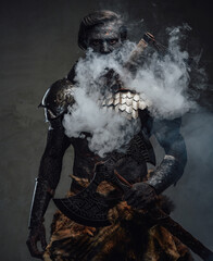 Muscular and scary warrior exhaling smoke and holding a huge axe