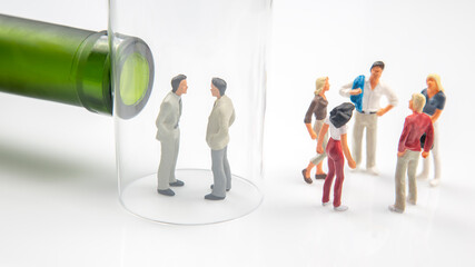 miniature people. man addicted to alcohol on the background of a bottle of wine and a glass. the problem of alcoholism in society and family relations.