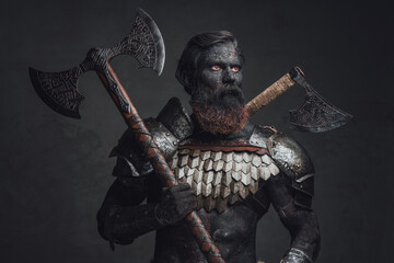 Scorched barbarian holding axe and staring away in dark background