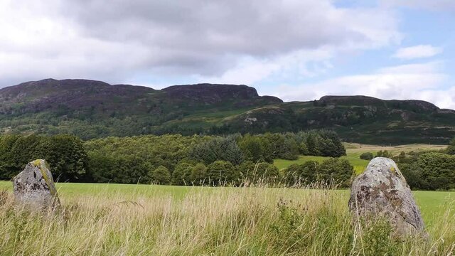 Pan right to left of two ancient standing stones in Highland Perthshire. Filmed near Comrie, Scotland.