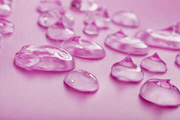 Drops of antiviral gel on a pink background with free space.