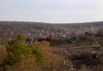 Fototapeta na wymiar Ukrainian village, spring hills, houses and forest 