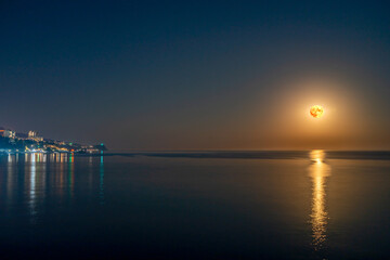 Naklejka premium Super full blood moon and moon light over the sea