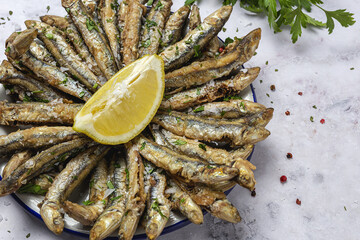 Traditional fried anchovies with lemon and parsley