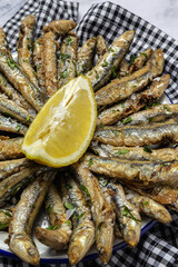 Traditional fried anchovies with lemon and parsley