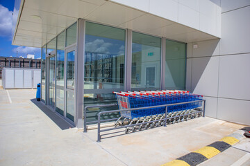 Hypermarket entrance with parked carts waiting for shoppers.
