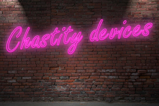 Neon BDSM Chastity devices (in german Keuschheitsgürtel) lettering on Brick Wall at night