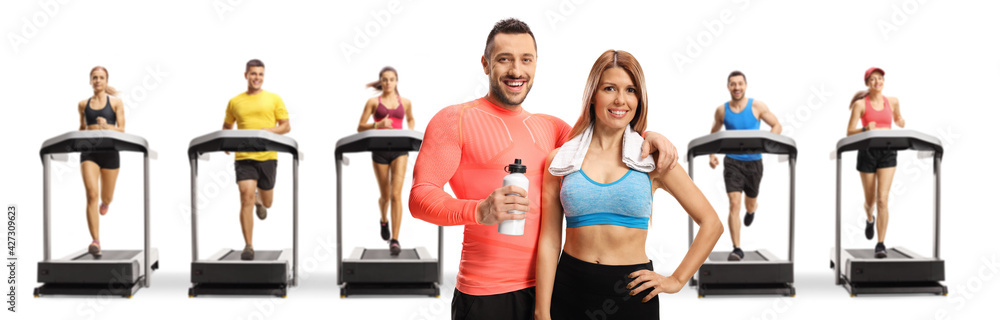 Poster Young man and woman in sportswear with people running on treadmills in the back