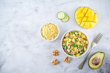Millet mango avocado cucumber salad in a bowl