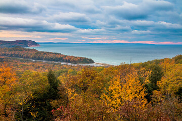 colorful autumn foliage in the Sleeping Bear Sand Dunes National Lakeshore overlooking dramatic...