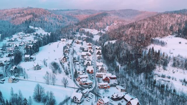 Zakopane, Poland. Arial view of a little town with small houses in a mountain landscape. Street, Houses, and trees, covered in snow with blue sky in the background. 