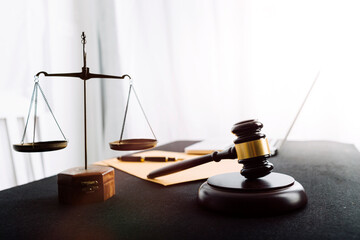 Business and lawyers discussing contract papers with brass scale on desk in office. Law, legal services, advice, justice and law concept picture with film grain effect