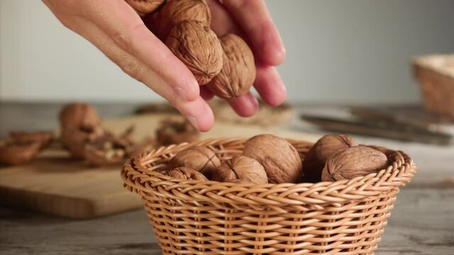 Hands dropping nuts into a basket in slow motion