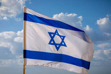 Israel flag with sky at sunset in the background