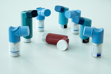 Various asthma spray inhalers on a white surface