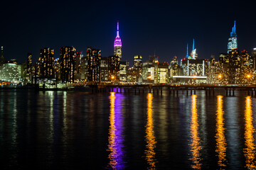 Fototapeta na wymiar The lights of Midtown Manhattan reflected in the East River at night.