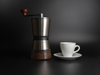 Manual coffee grinder, cup  on a black background.