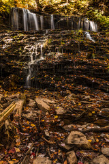 colorful autumn foliage with calming cascading waterfall in Pennsylvania.