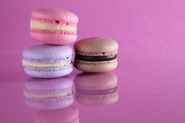 Three macaroons on a pink background. Pink macaroons on a table. Lifestyle on a pink background color fuchsia with a place for text and with a copyspace