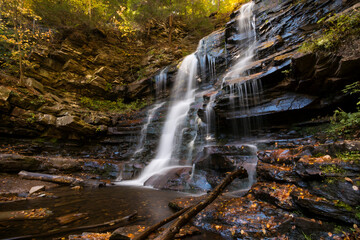 colorful autumn foliage with calming cascading waterfall in Pennsylvania.