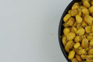 Roasted corn with mustard and honey in the black bowl. Top view.