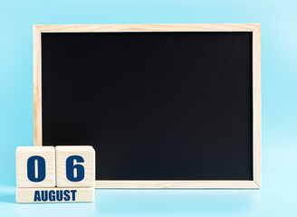 August 6th. Day 6 of month, Cube calendar with date, empty frame on light blue background. Place for your text. Summer month, day of the year concept