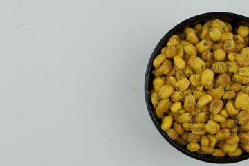 Roasted corn with mustard and honey in the black bowl. Top view.
