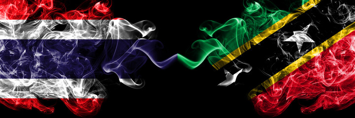 Thailand, Thai vs Saint Kitts and Nevis smoky mystic flags placed side by side. Thick colored silky abstract smokes flags.
