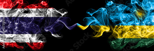 Thailand, Thai vs Rwanda smoky mystic flags placed side by side. Thick colored silky abstract smokes flags.