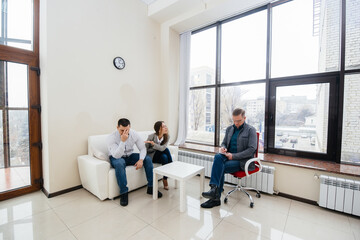 A young married couple of men and women talk to a psychologist at a therapy session. Psychology.